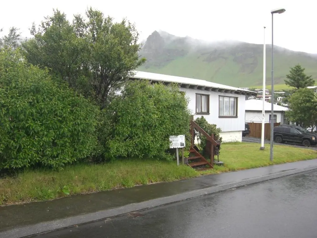 Guesthouse Galleri Vík exterior with mountains behind in Vík, Iceland